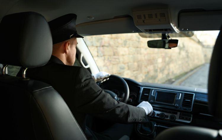A chauffeur in a luxury black car vehicle