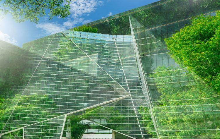 A greenhouse-looking corporate building with plenty of trees surrounding it