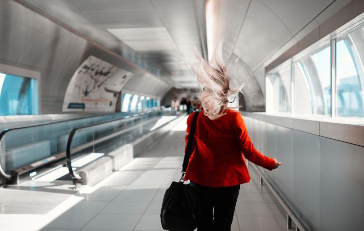 A woman rushing through a long hallway in an airport