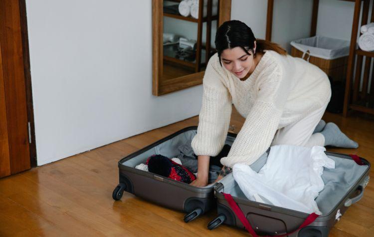 Girl making room in a suitcase