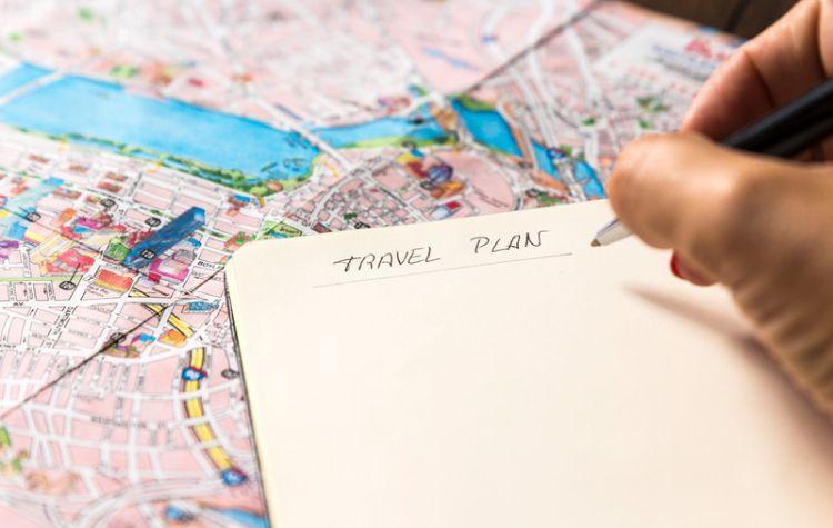 Notebook open on a map labeled Travel Plans