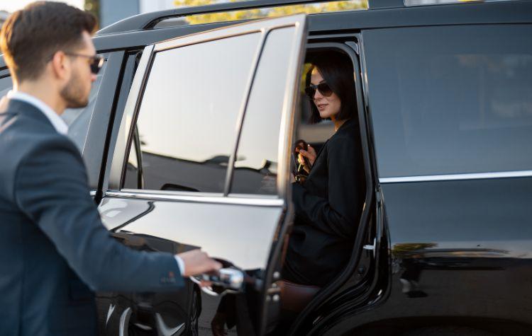 A lady in glasses using black car service