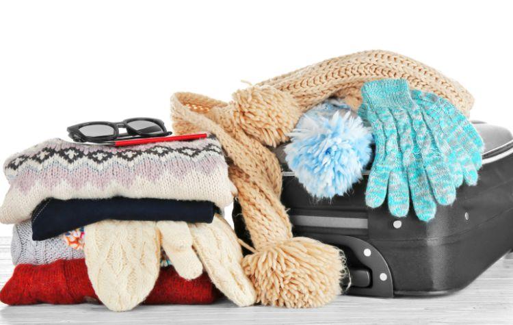 Winter items on top of a suitcase
